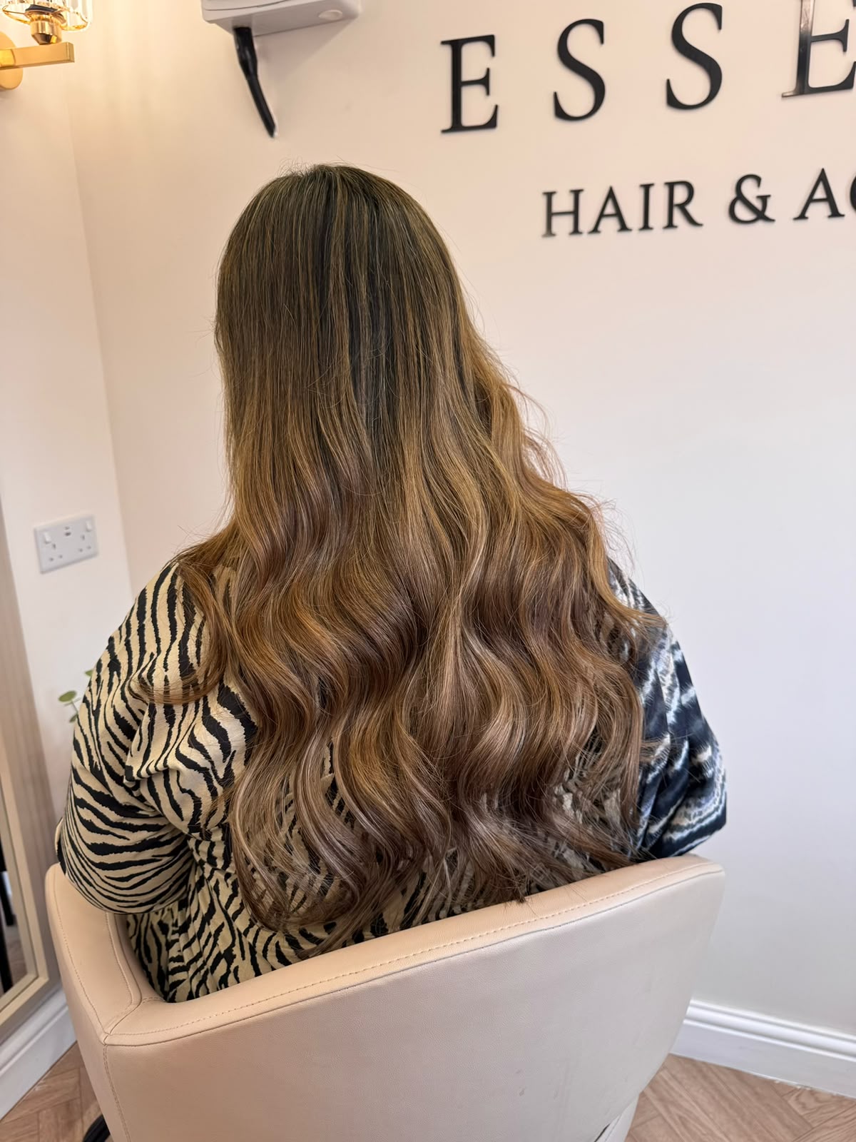 Brunette-to-caramel balayage waves under the Essence sign