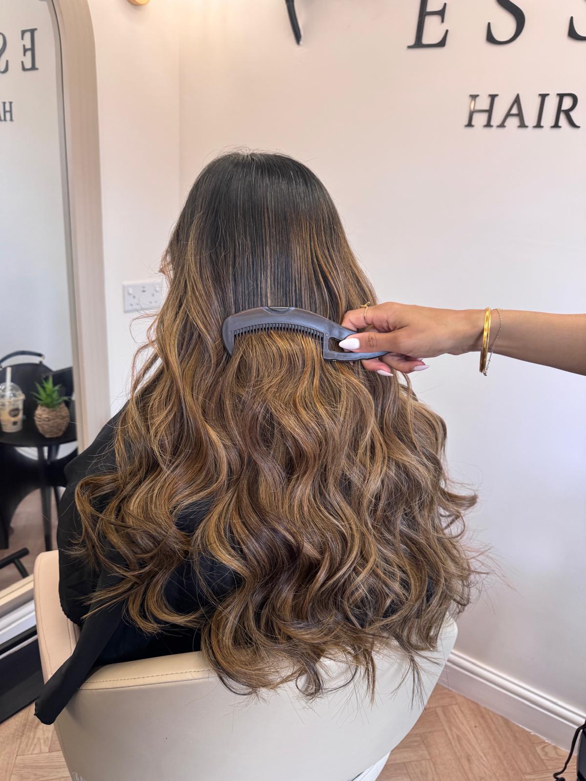 Long brunette hair with caramel balayage and soft curls