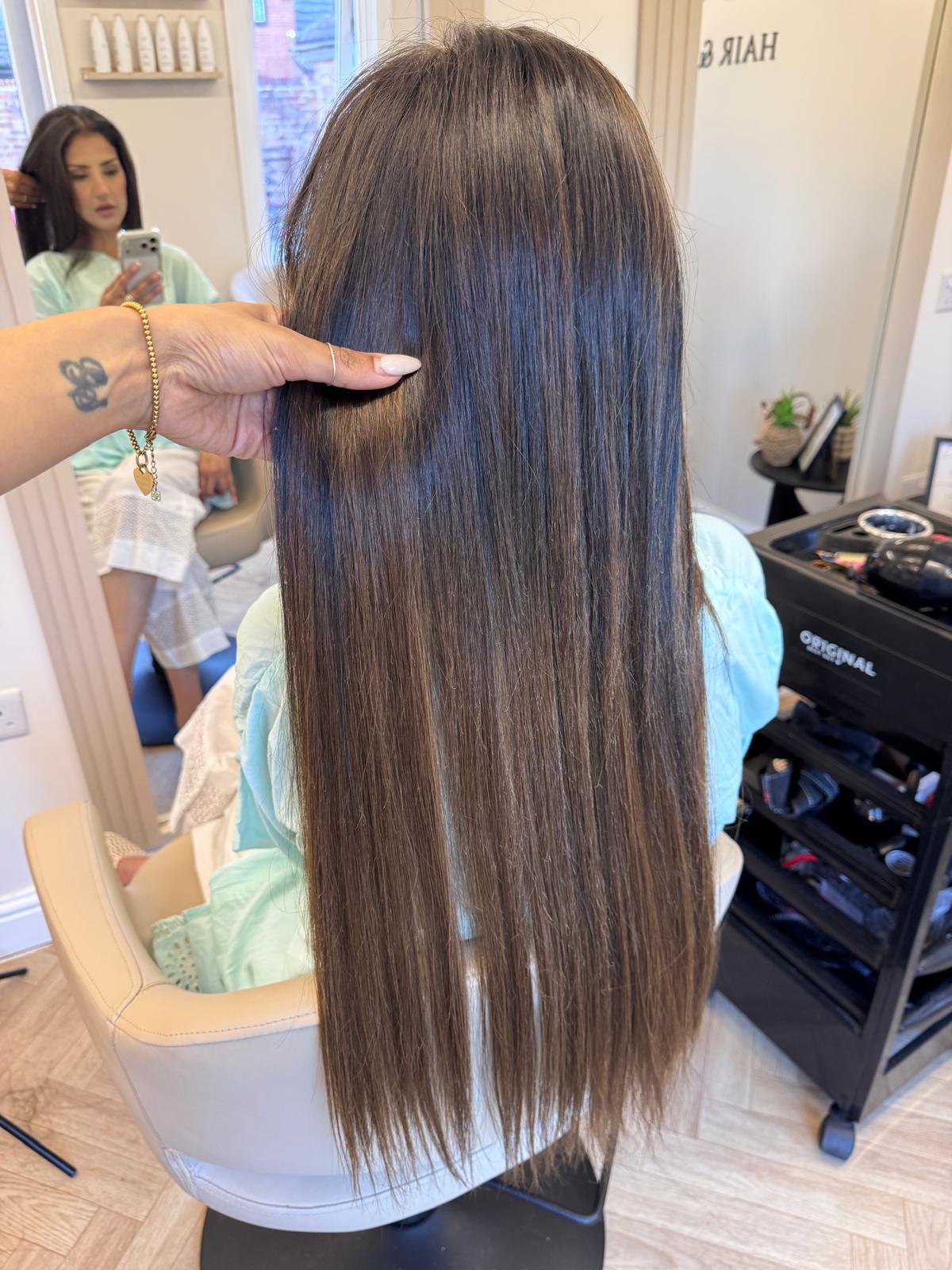 Long, straight brunette hair with tape-in extensions